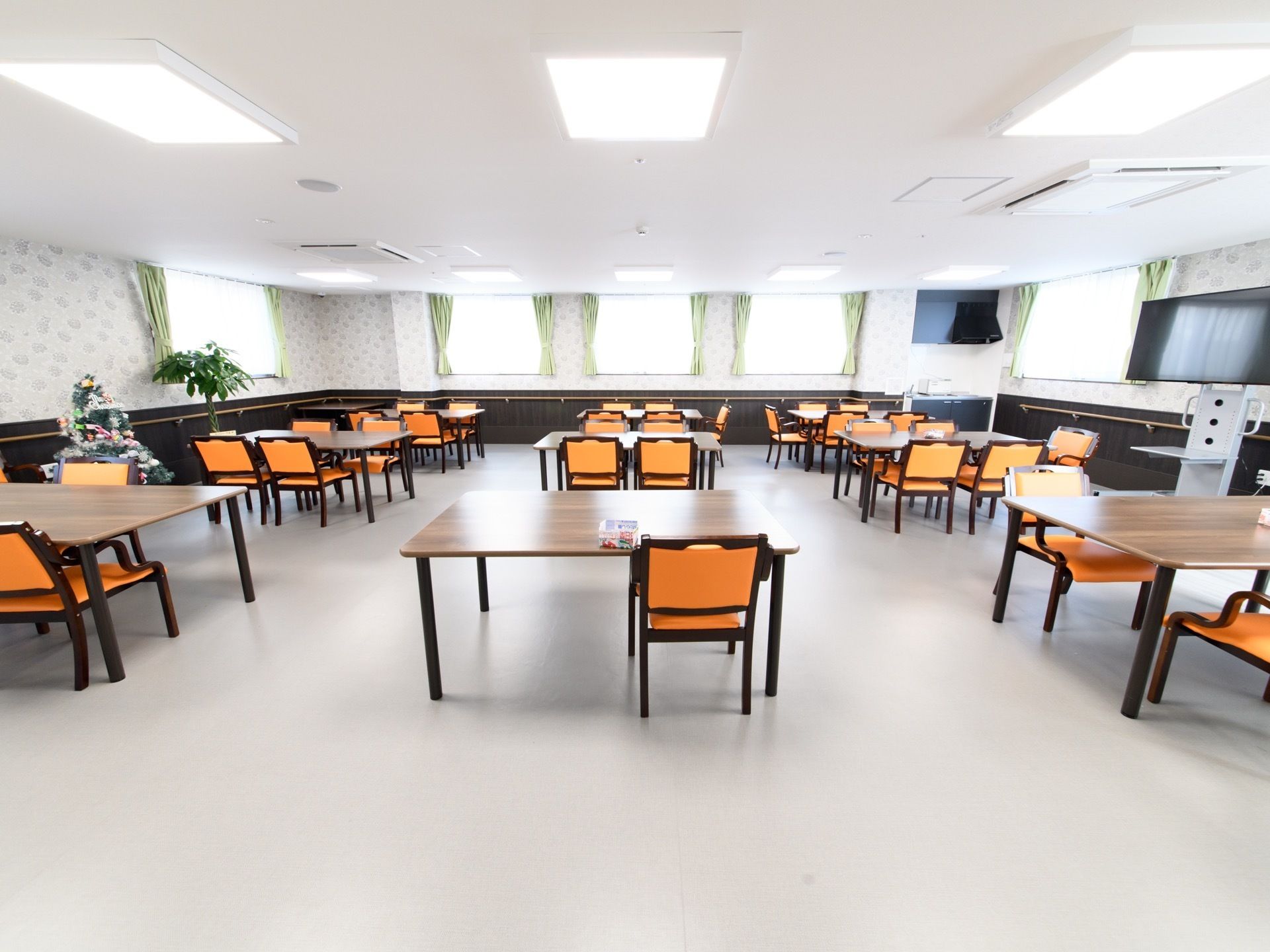 ゆったりとした清潔感のある明るい食堂には、4人掛けのテーブルセットや大型液晶テレビが完備されている。