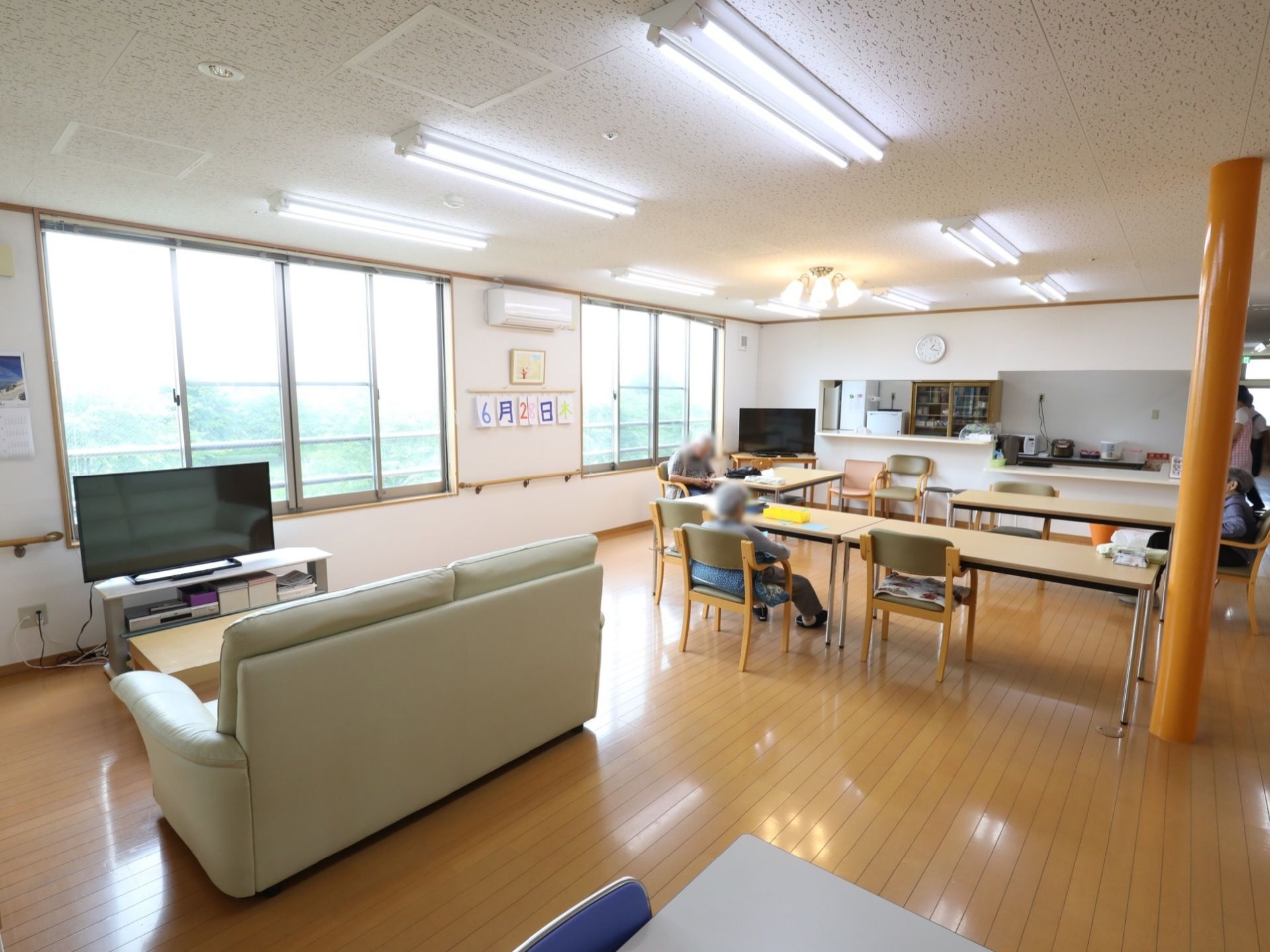 明るい木目のフローリングに、鳥の子色の壁紙を採用した爽やかで開放的な空間である。柱は明るいオレンジ色で、部屋を彩るインテリアにもなっている。