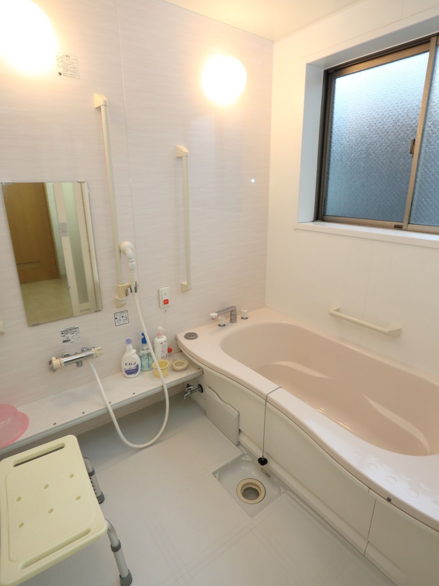 浴室には窓がついている。シャワーと湯船の近くには手すりを取り付けてある。シャワー前には、洗面器がのるほどの台がある。