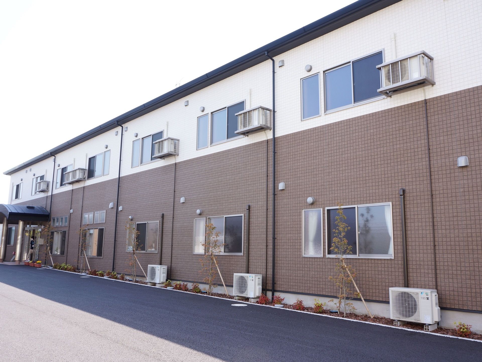 施設は鉄骨造の2階建てである。上下、均等に窓が取り付けられている。また、空調用の室外機も窓同様に上下に並んで設置されている。