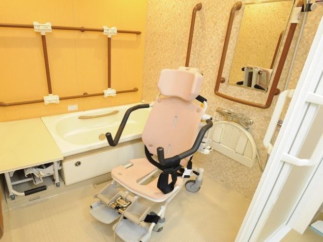 個室タイプの浴室。搬送車が設置されており、スタッフのサポートのもと安全に入浴することができる。浴槽内に手すりがついている。