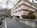 道路に面して建てられている。施設は4階建てでピンク色と白色である。周りは剪定された葉が植えられている。