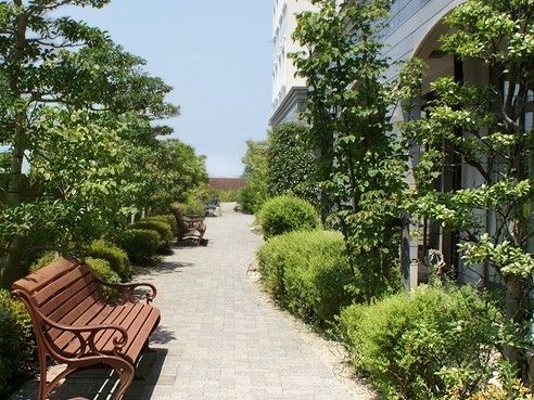 生い茂った緑の植物の中、長椅子に座って時間を過ごすができるガーデン