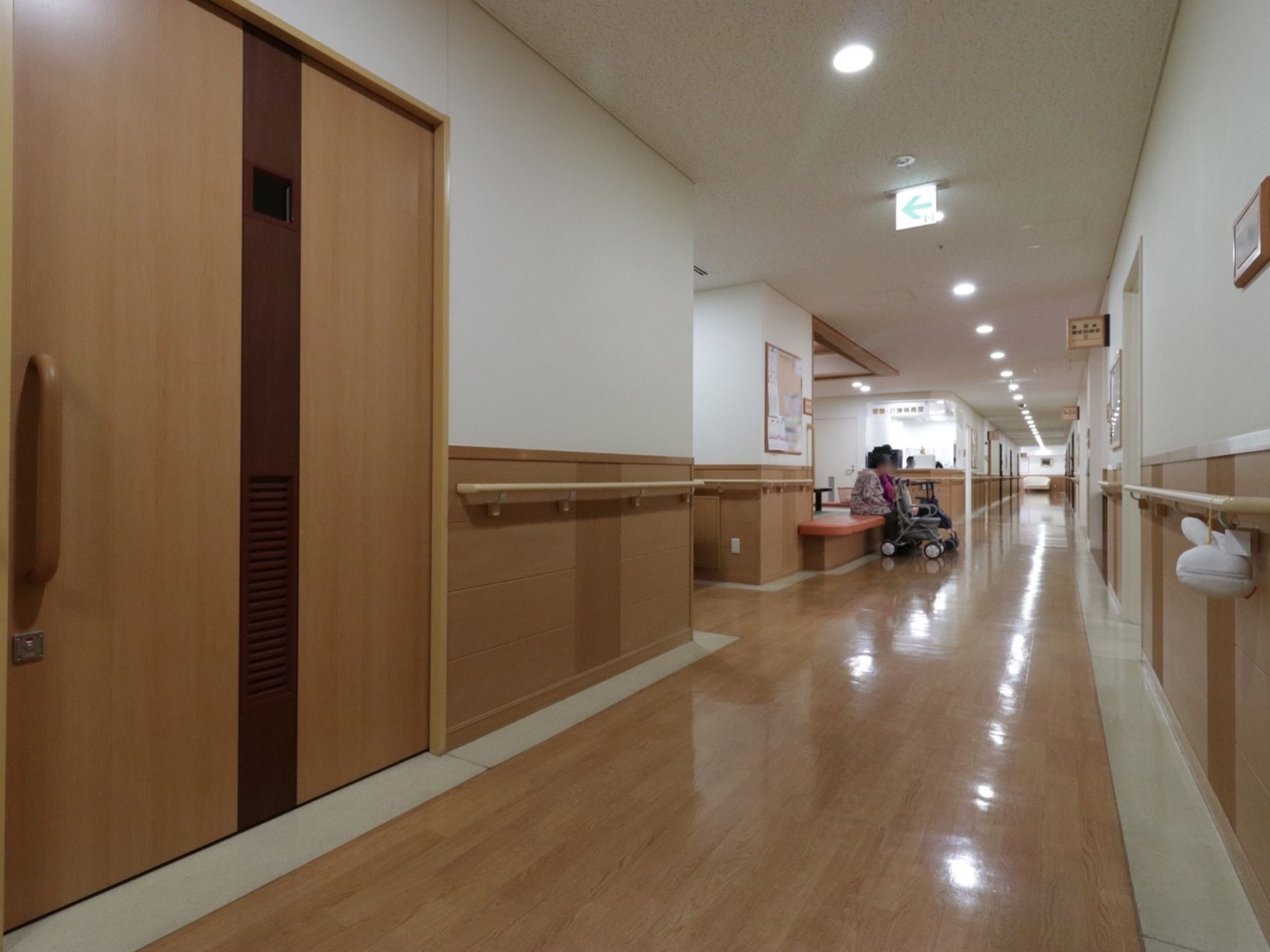 壁には手すりが取り付けられている。廊下には照明が一定間隔で設置されており明るい。途中で座ることができるスペースがある。