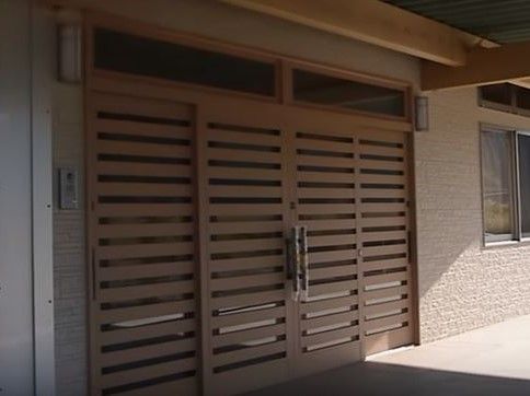 木が使われた落ち着いた雰囲気の玄関で、スライド式になっており安全に開閉することができる。玄関前は屋根があり、雨の日も安心である。