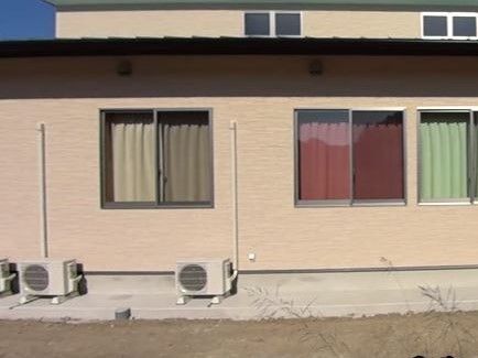 外壁は淡いブラウン色で、優しく落ち着いた雰囲気がある建物である。各部屋にはカラフルな色のカーテンが掛けられている。