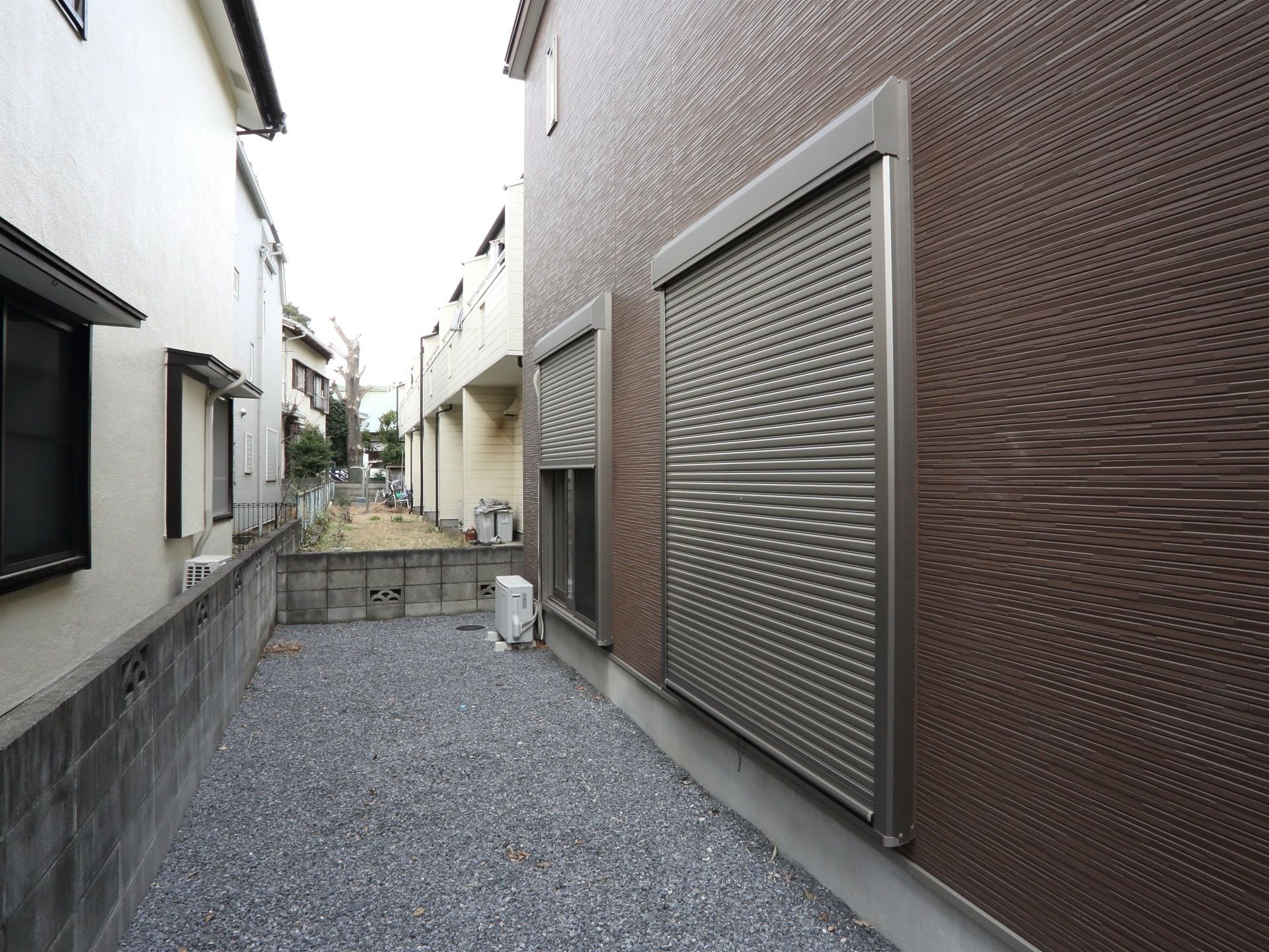 住居の周りには、砂利を敷き詰めた犬走りがある。そして家との境は、塀で囲っている。１階の窓には雨戸を完備している。