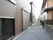 建物の外の通路は広く、砂利が敷き詰めてある。周りにも２階建ての一戸建て住宅が並んでいる、環境にある。