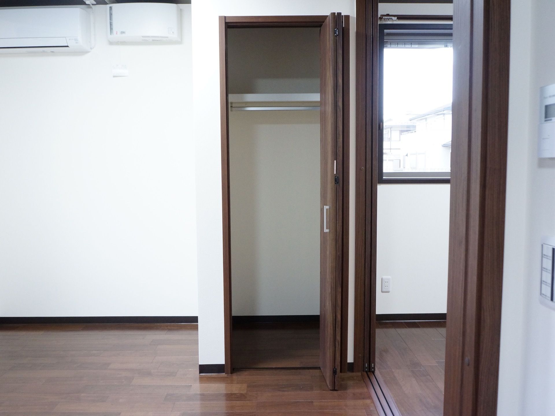 白い壁に木目調のフローリングを用いた部屋である。クローゼットには洋服だけではなく、上部にも棚があり小物などが収納できる。