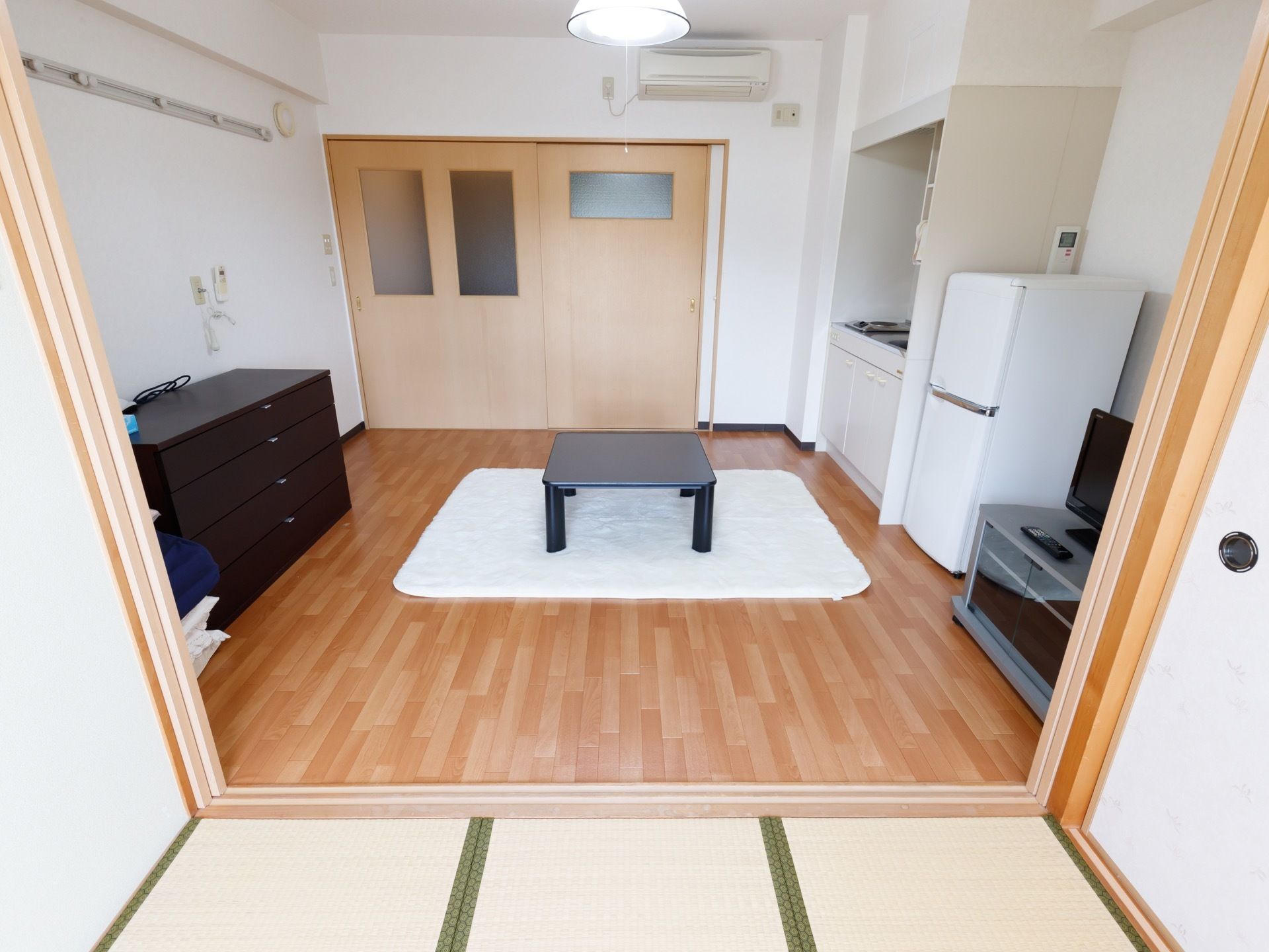 居室はフローリングの洋間と畳のスペースが一体になった特徴的な構造になっている。部屋の隅にはキッチンも備えてある。