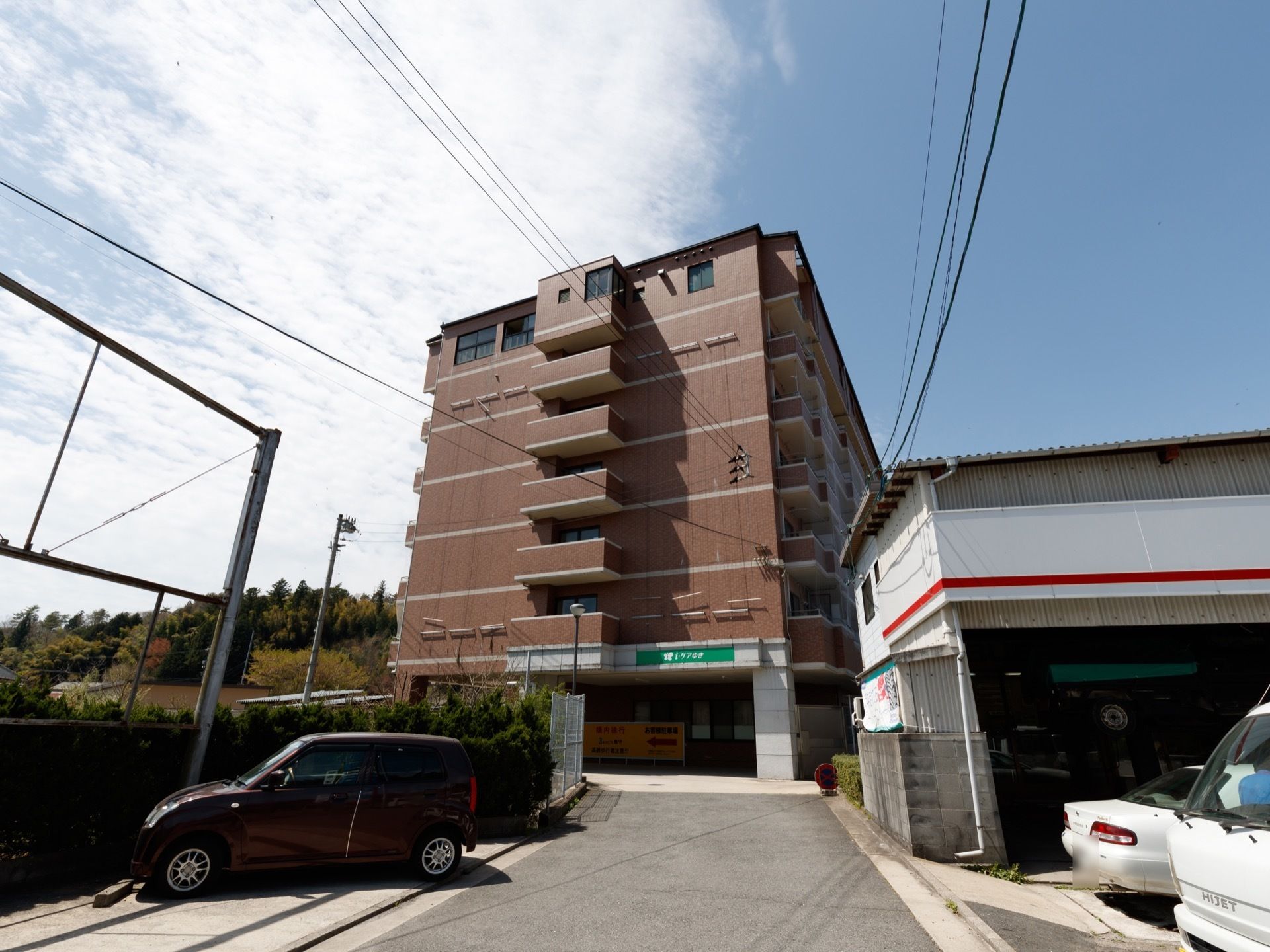 施設はマンションタイプの大きな建物に収まっている。一階部分は自動車で通り抜け可能で、中は駐車場になっている。