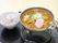 ある日の一食事である。黒いお盆にカレーうどんがアルミ鍋に用意されている。茶碗にはご飯がよそわれている。