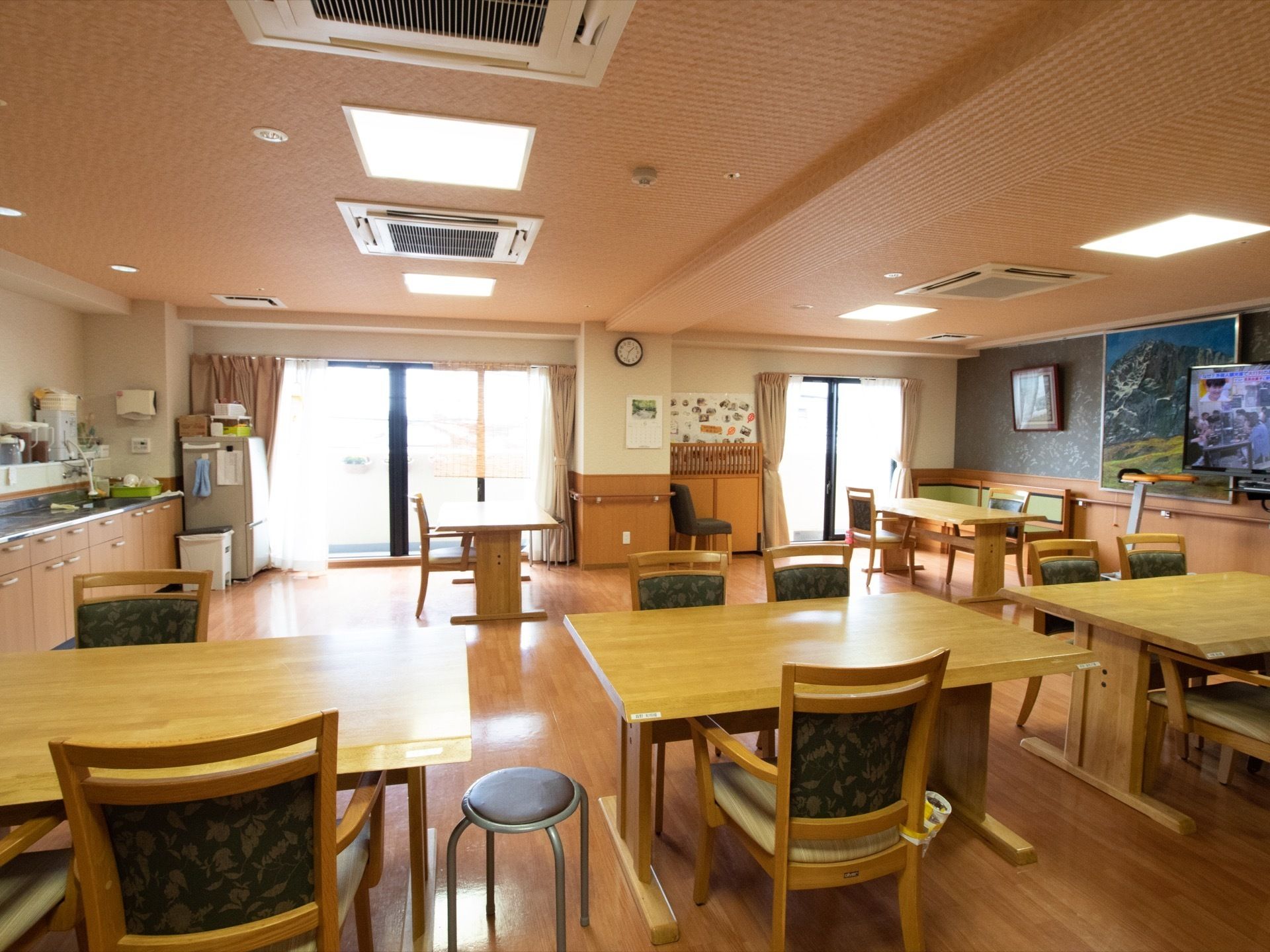 入居者様が集う共有スペースには、流し台や冷蔵庫などを備えたキッチンを設けている。天井に複数のエアコンを設置している。