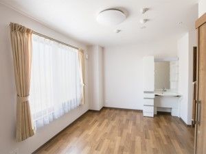 左手の壁には、レースのカーテンが掛かった大きな窓があるため、室内はとても明るい。奥側の壁際には、白い洗面台がしつらえられている。