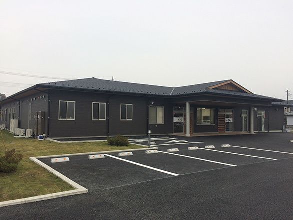 平屋建てで黒を基調とした落ち着いた外観。玄関は段差がなくスムーズに入館していただける。駐車スペースも広く確保されている。