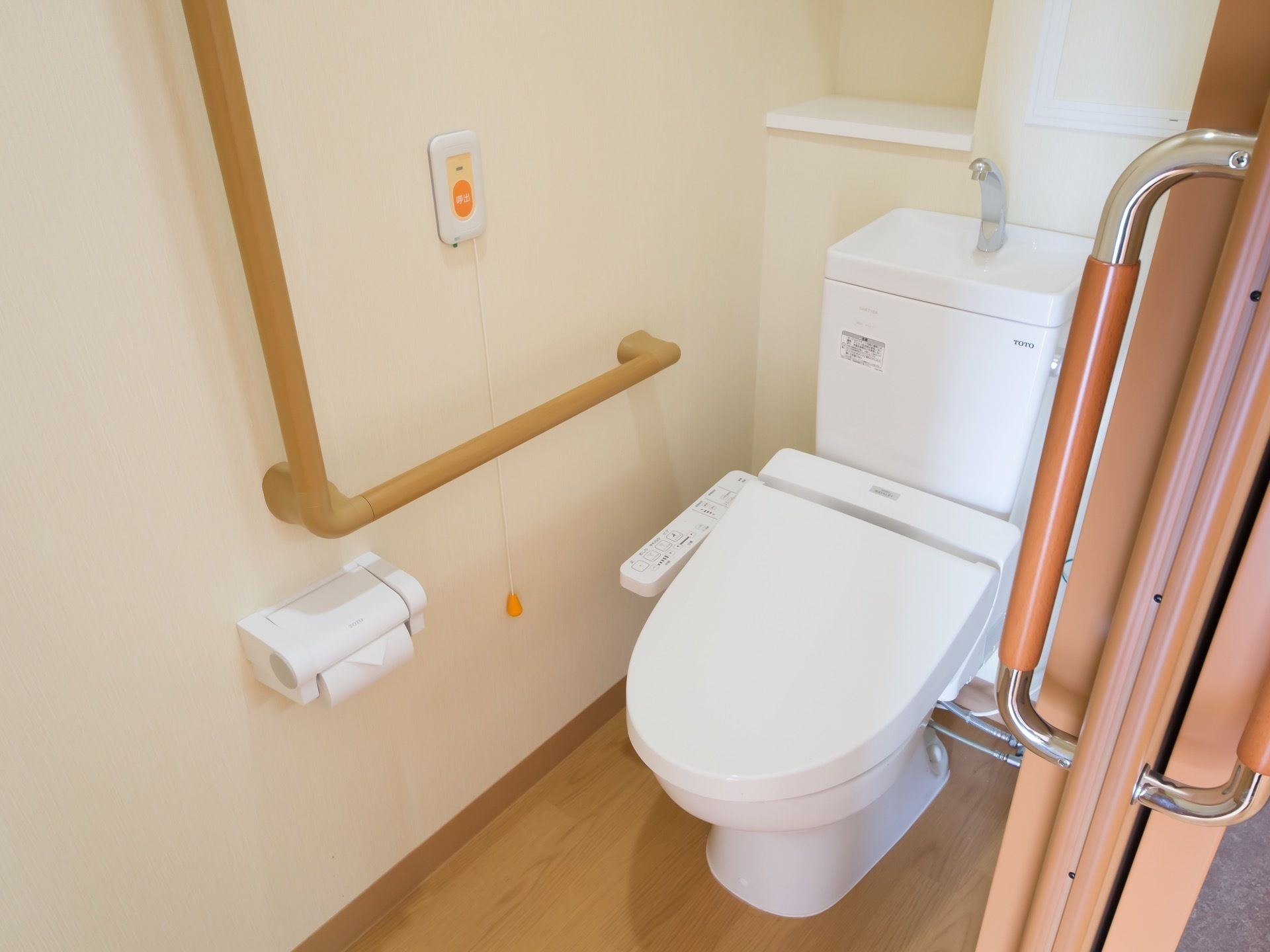 安全対策で、ナースコールや手すりを設置している。小さな棚にはトイレットペーパーなどをストックすることができ、便利である。