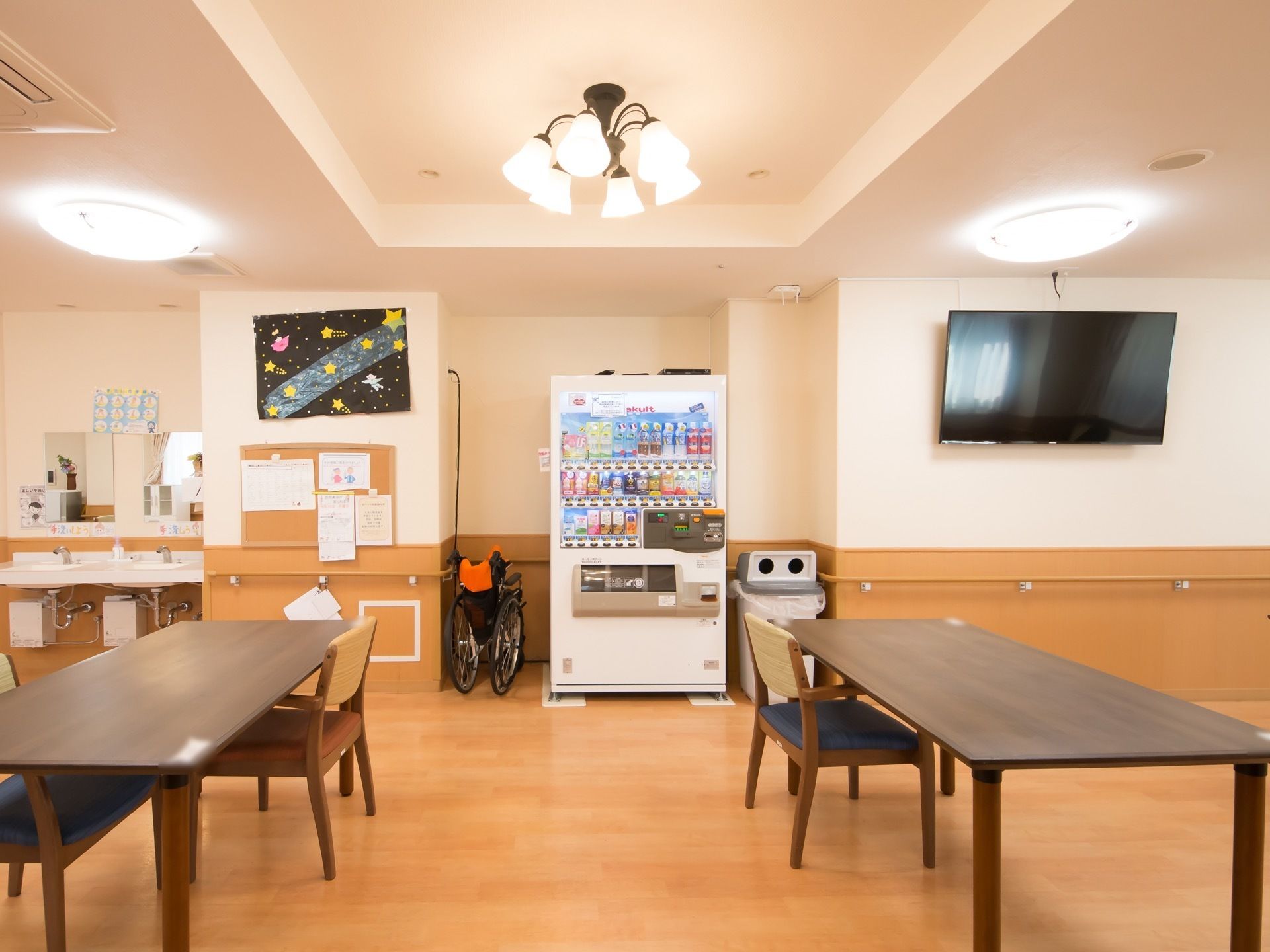 食堂には大きな壁掛けテレビを設置している。自動販売機で飲み物を購入し、好みの場所でお茶を楽しむことができる。