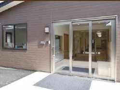 施設玄関は横開きのドアが設置されており、ドアの開閉が楽にできる。段差がなく、車椅子や杖をご利用の方も出入りしやすい。