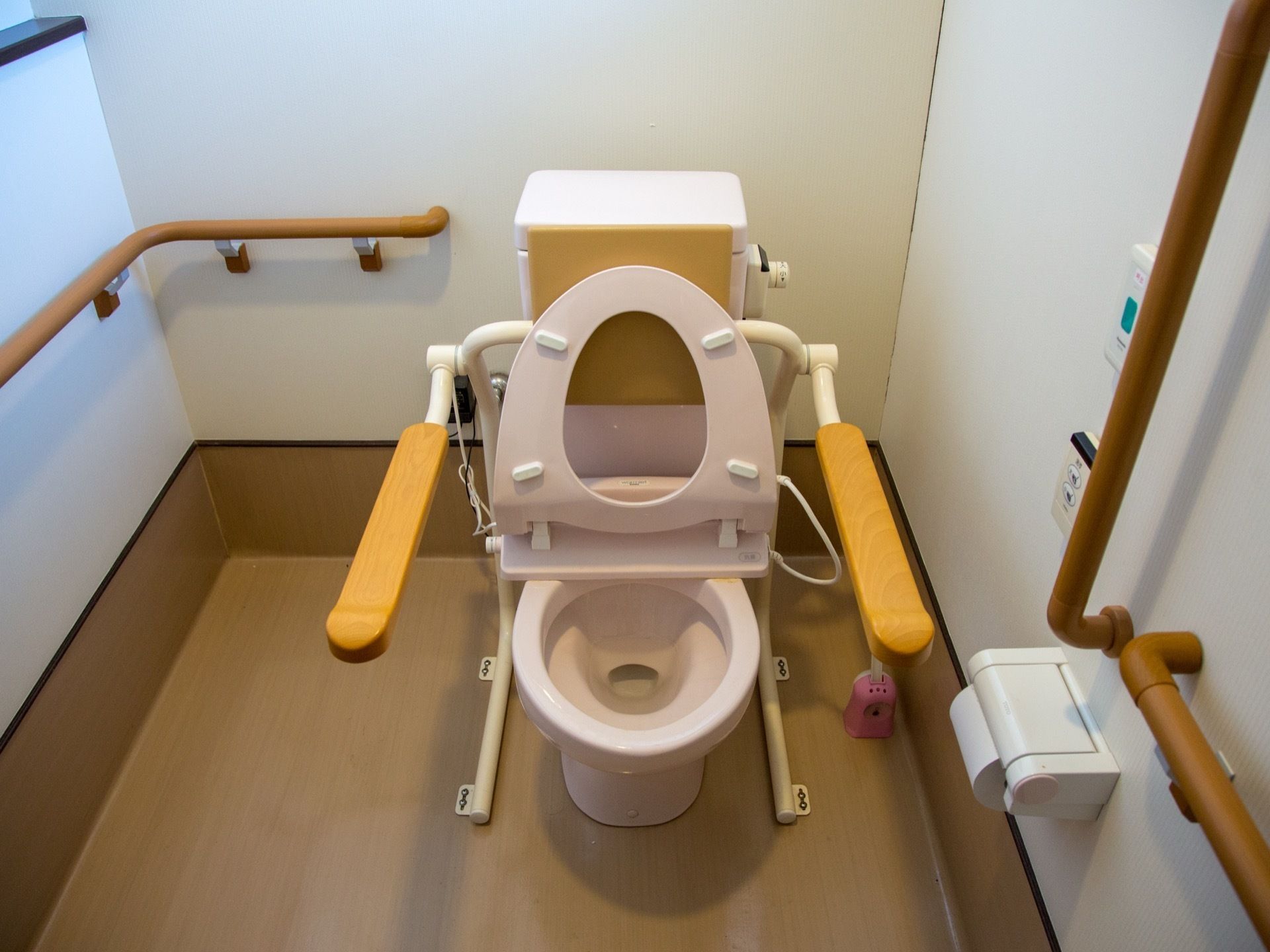 トイレには洋式便器が設置されている。便器の両脇には可動式の手すり、壁側には固定式の手すりが取り付けられている。