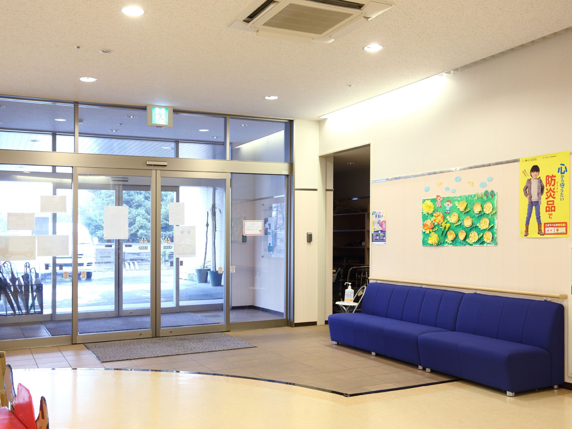 真っ青のソファが目を引く、消毒液が設置されたエントランスホール