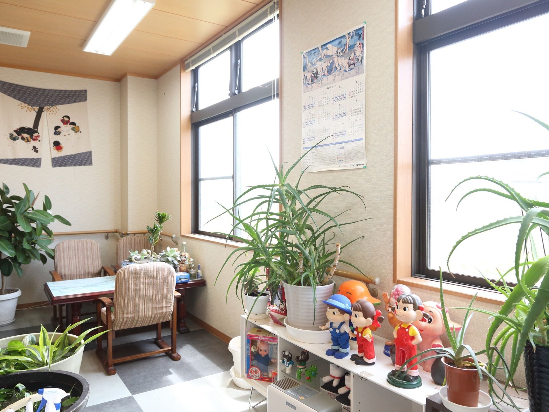 エントランスには、椅子やテーブルが並べられている。その周辺には、植木鉢に植えられた植物がたくさん飾られている。