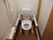 トイレには壁に手すり、便座周辺にはひじ置きと背もたれが設置されている。トイレットペーパー掛けが２か所取りつけられている。