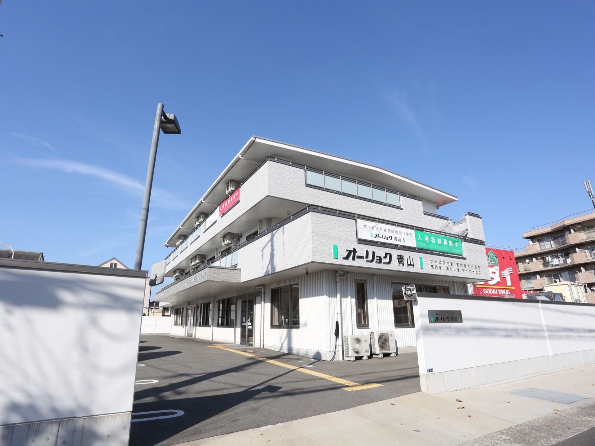 落ち着いた色合いに施された、3階建ての施設である。外壁には施設名が記されており、道路から目立ちやすい。