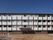 外壁は白とブラウンの２色を使っている。4階建ての横に長い建物である。建物前の敷地は広い駐車場になっている。