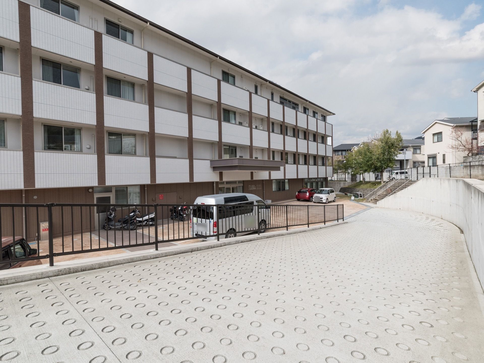 施設は閑静な住宅地にあり、穏やかな環境になっている。広い駐車スペースを設けているので、車で玄関前まで行ける。