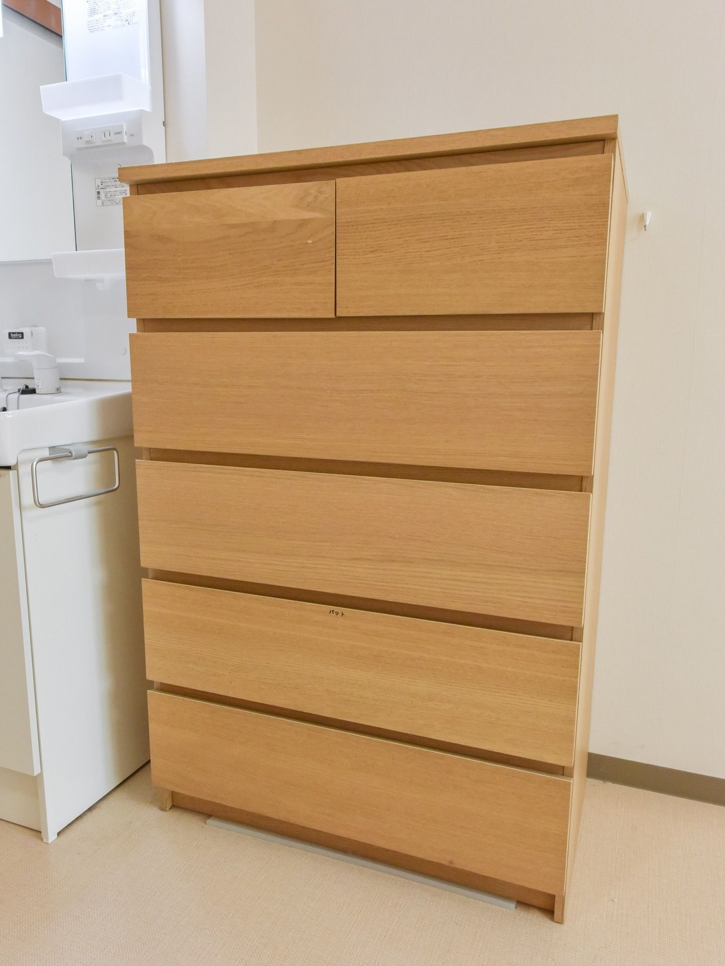 居室には鏡のついた、洗面化粧台が用意されている。また広々とした室内には、木目調のローチェストが置かれている。