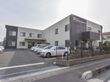 グループホームの建物は２階建てで、ツートンカラーの外壁となっている。また敷地には垣根があり、柵が取り付けられている。