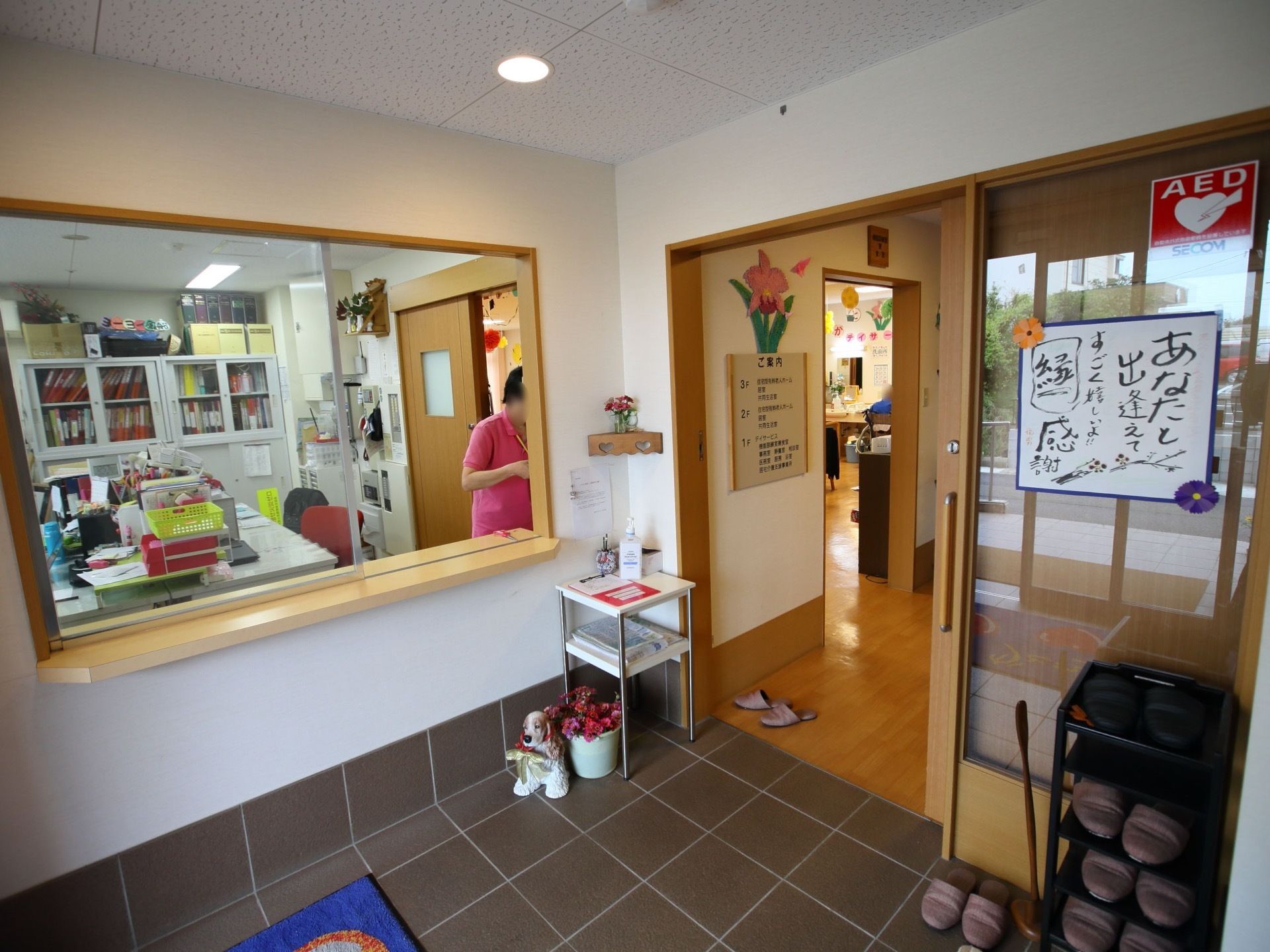 青いマットが敷かれた玄関があり、左手に事務所のカウンターがある。室内とは引き戸で仕切られていて、段差のない造りになっている。