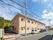 オレンジベースの2階建ての施設である。道路側の壁面には、花のマークと施設名が大きく描かれ、施設の脇に駐車スペースがある。