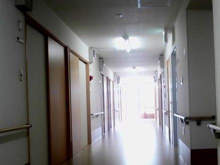非常口の看板が設置されている。廊下の突き当りには消火器が置かれている。通路幅は広く設けられているので、通行しやすくなっている。