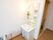 居室に完備されているトイレのスライド式扉は開かれている。洗面化粧台が設置され、ライトが点けられている。