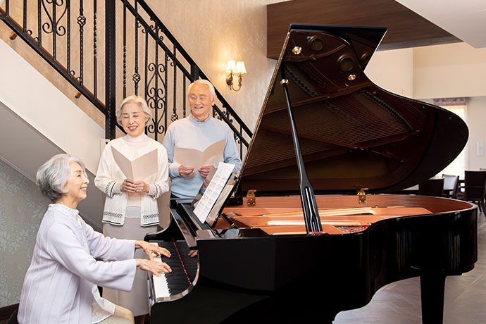 ベッドに横になる女性入居者様と、その傍に付きそう2人の女性スタッフ