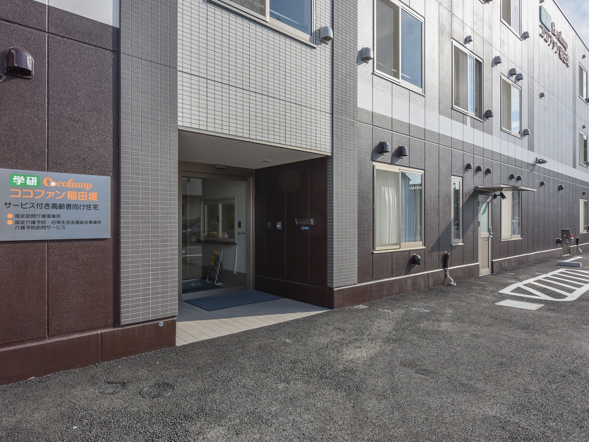 ダークブラウンやグレーなど、落ち着いた色合いで揃えた外観である。建物の周りは舗装されており、入り口に段差はない。