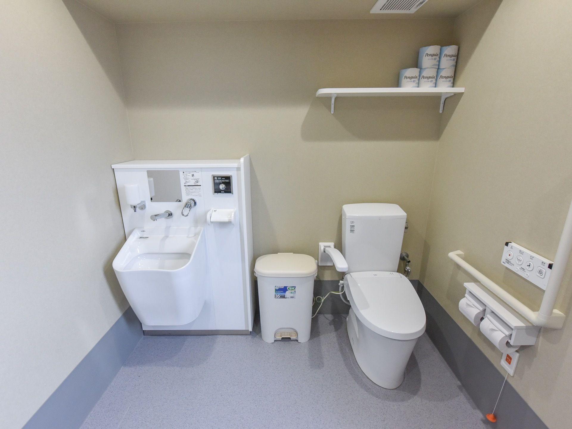 温水洗浄便座と、オストメイトの方でも利用できるトイレが設置されている。壁には手すりや操作ボタン、呼び出しボタンなどが取りつけられている。
