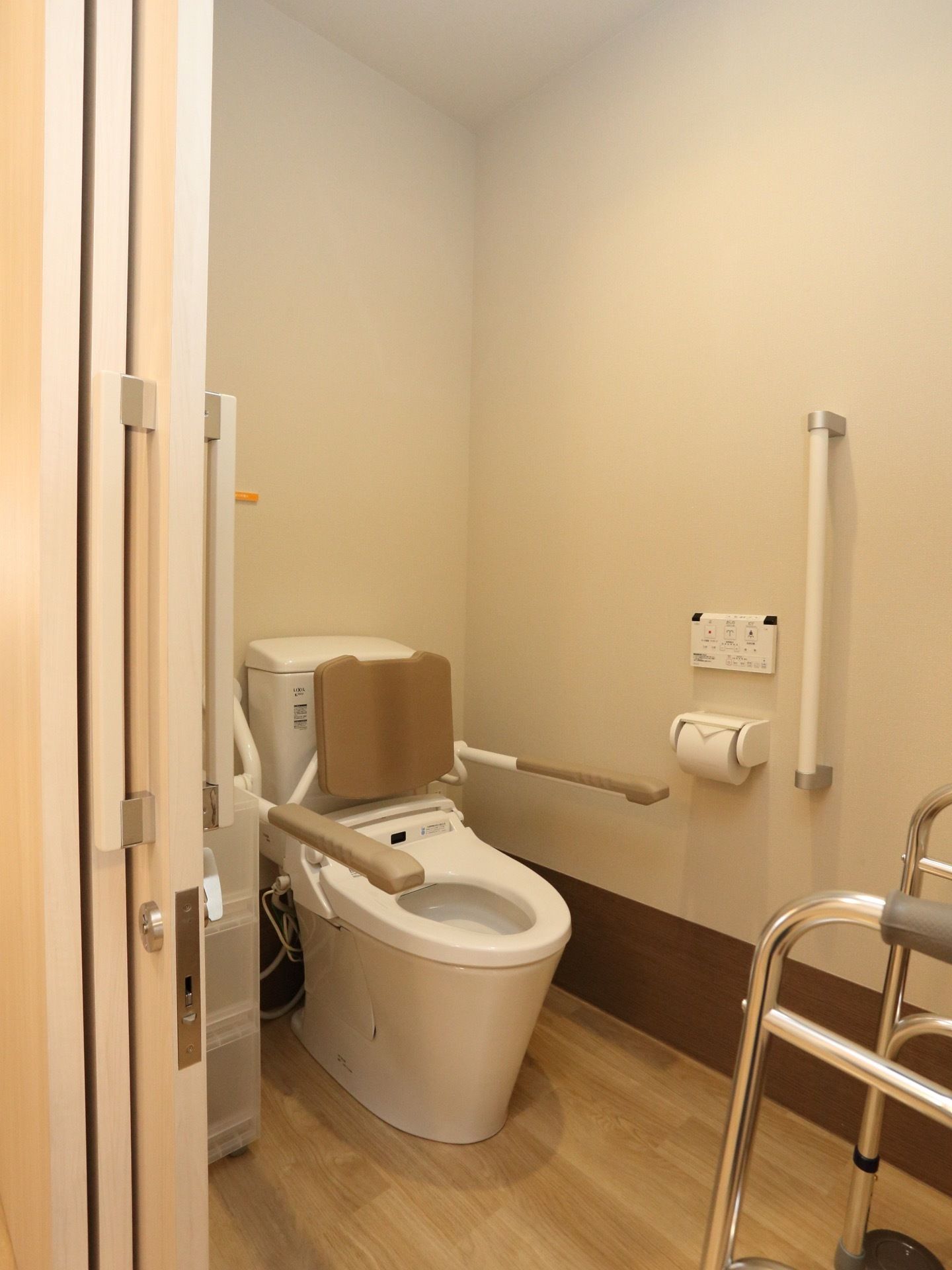 トイレは温水洗浄便座付きで、操作パネルは壁に設置している。洋式便器には背当てパッド付きの手すりを取り付けている。