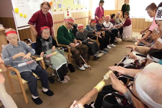 介護スタッフと大勢の入居者様で、一つの競技に取り組む様子