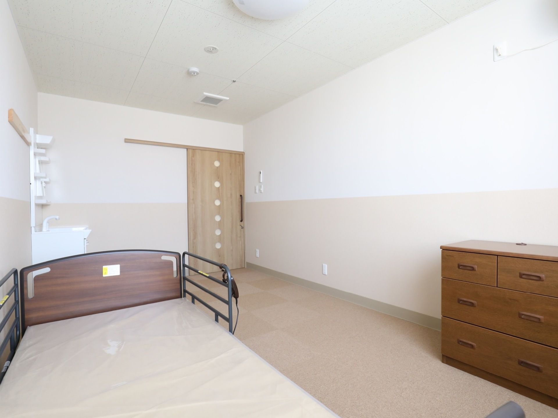 白を基調としたシンプルな長方形の部屋である。スライド式のドアの横には、収納力のある洗面台が備え付けてある。