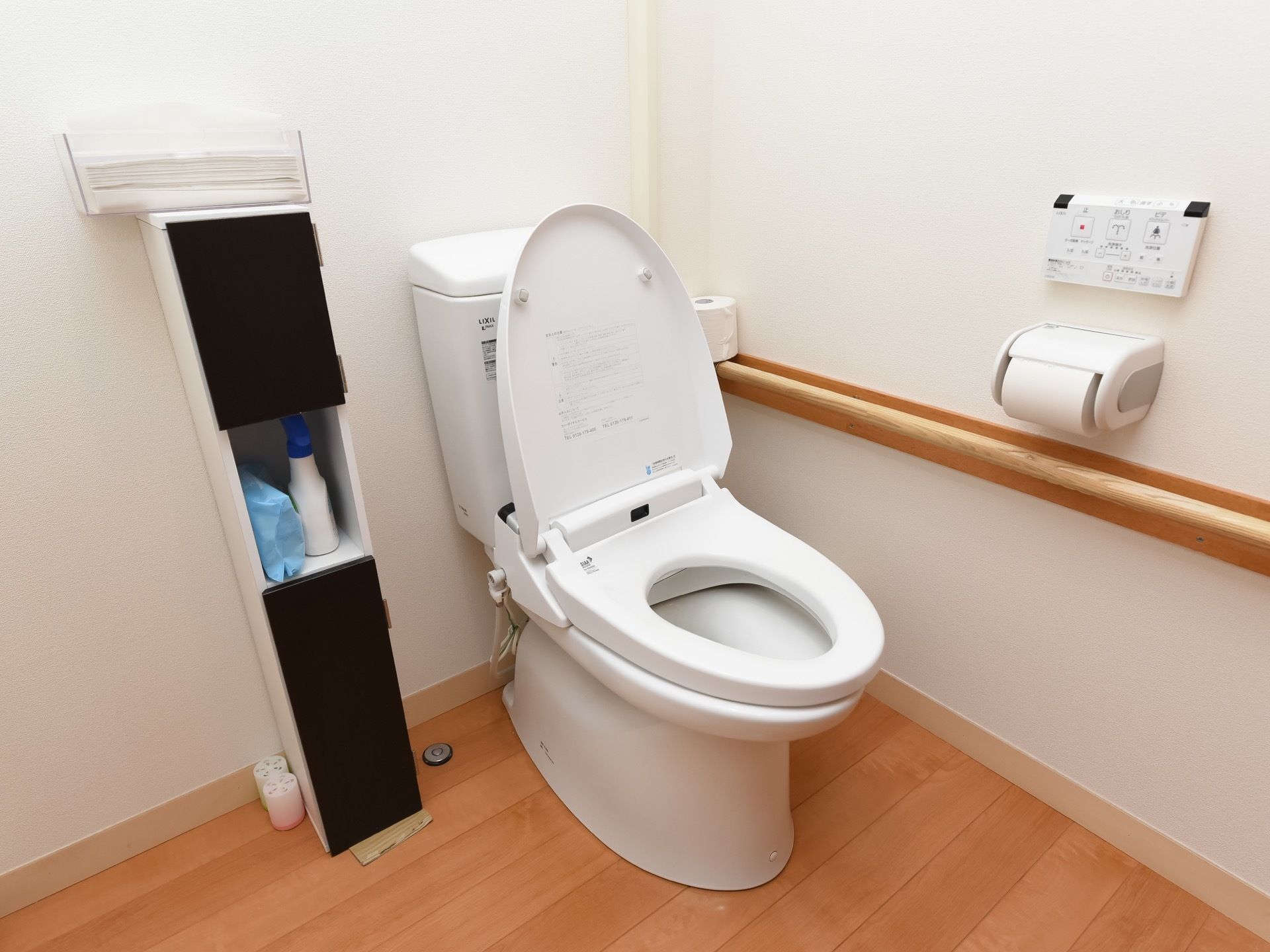トイレは温水洗浄便座を取りつけている。壁に棚が取りつけられ、掃除シートなどが収納されている。その上にペーパータオルがある。