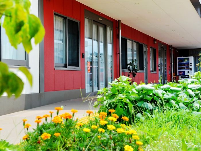 自然に囲まれたエントランス。オレンジの花が咲いている。