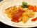 食事のメインとして平たいお皿にカツが乗せられている。カツにはトマトソースがかけられており、お皿にもソースで模様が描かれている。