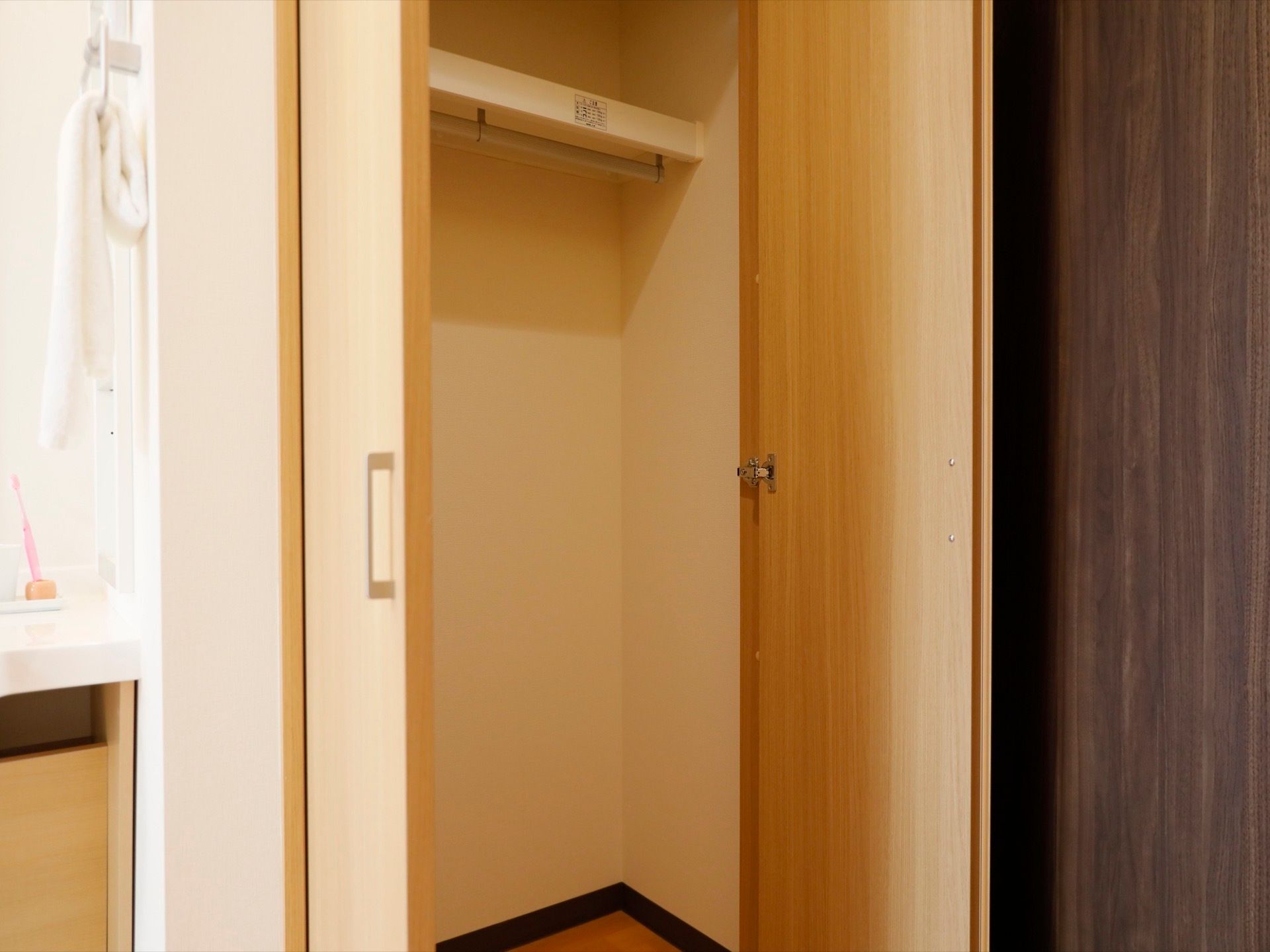 居室内に備えつけられたクローゼット。扉は観音開きになっており、洋服をかけることができるポールが取りつけられている。