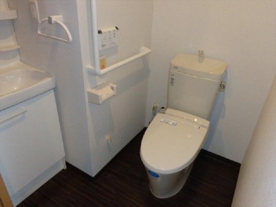 白を基調としていて清潔感のあるトイレになっている。洗面台も設置されていて、壁にはコンセントやタオル掛けが付いている。