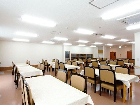 白いテーブルクロスが敷かれたダイニングテーブルが、等間隔で配置された食堂