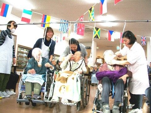 パン食い競争を楽しむ車椅子に乗った入居者様と、サポートするスタッフ