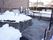 植栽には雪が残っているが、石張りのスロープは雪かきが済んでいる。スロープには手すりが設置されている。