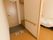 扉は開き戸タイプが採用されている。2人分のスリッパがならべられている。壁片側には手すりが完備されている。